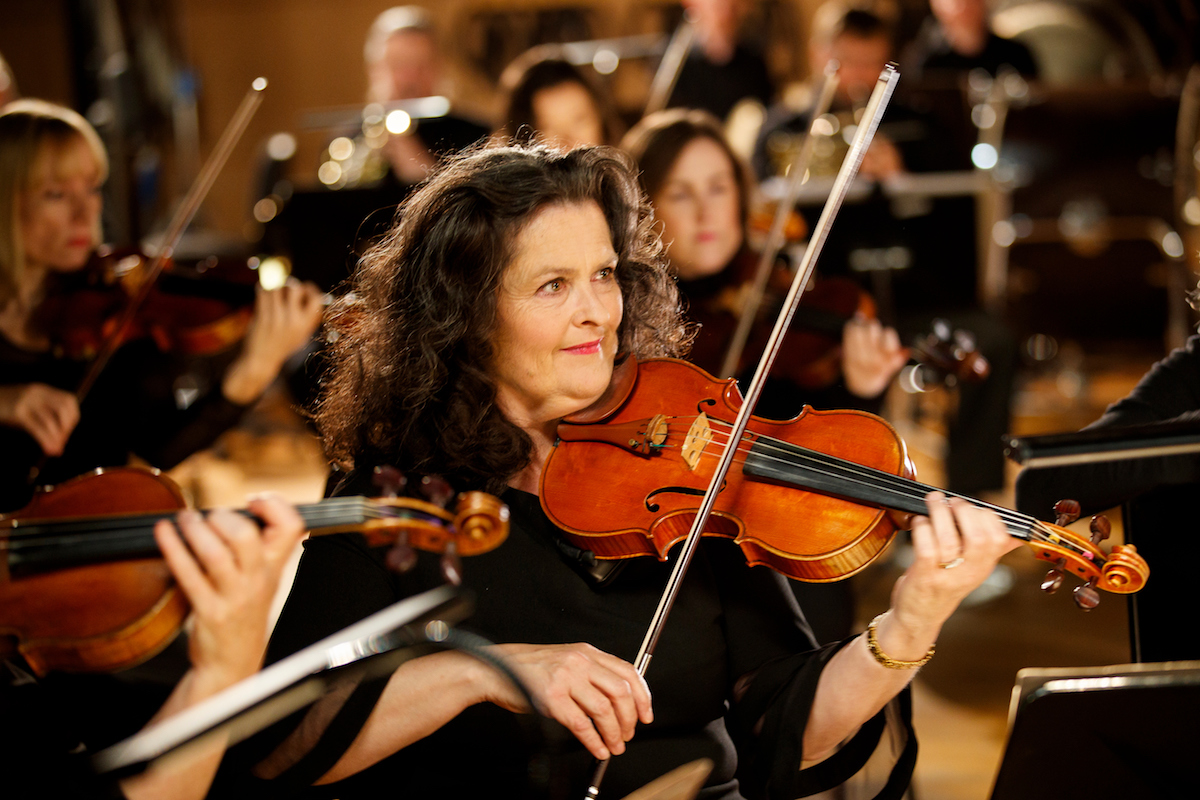 Woman playing violin and smiling